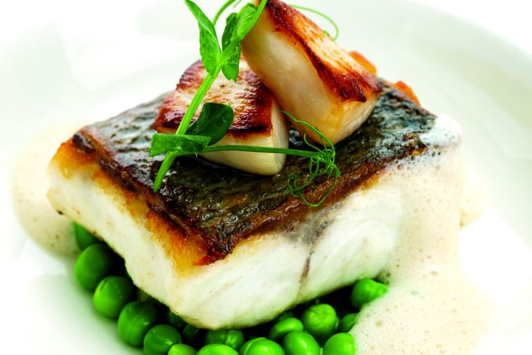 Pan-roast sea bass fillet with Jersey scallops and peas