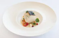 Roasted amberjack with cooked vegetable salad, fresh almonds and tomato water