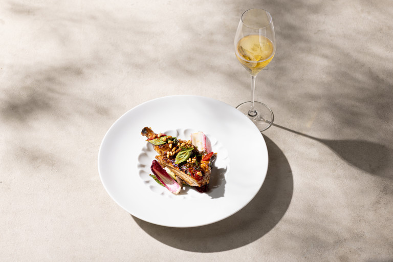 Grilled poussin with chicory salad, anchovies and pine nuts