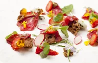 Carpaccio of beef with pickled strawberries, wild spicy leaves and ryvita