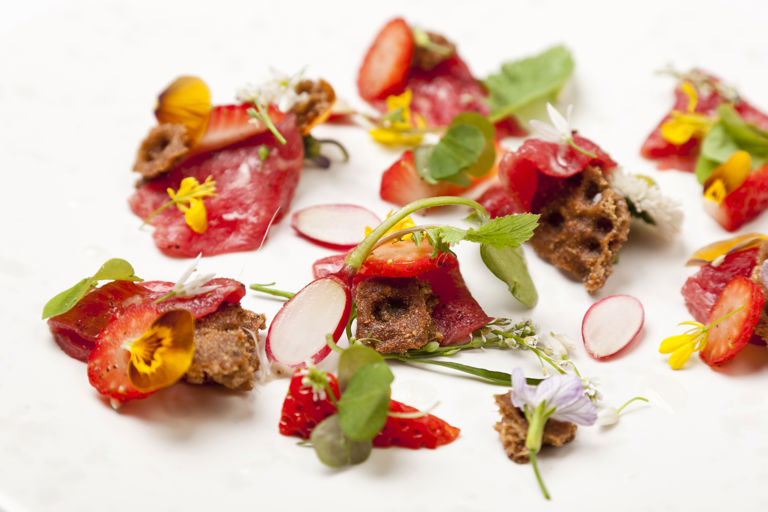 Carpaccio of beef with pickled strawberries, wild spicy leaves and ryvita