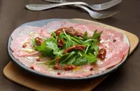 Beef carpaccio with pink pepper rocket and sun dried tomatoes