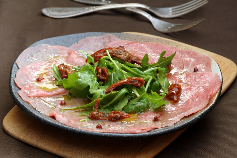 Beef carpaccio with pink pepper rocket and sun dried tomatoes