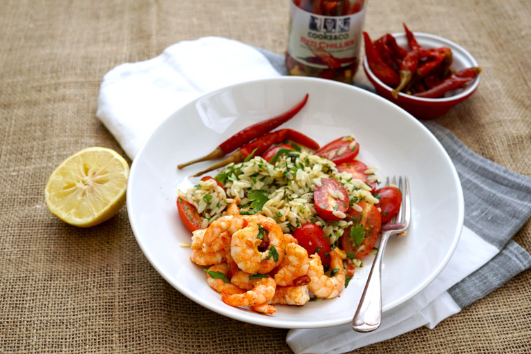 Sizzling prawns in chilli butter with orzo, herb and tomato salad
