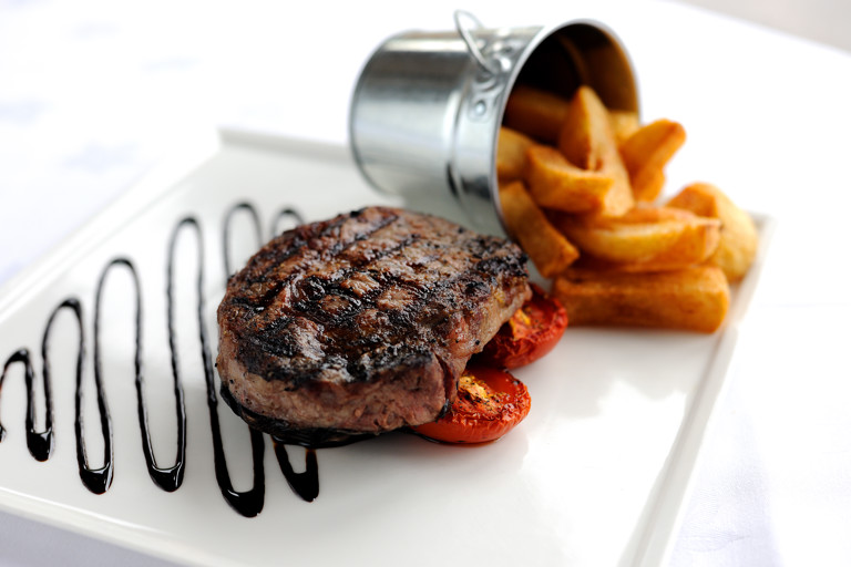 Rib-eye steak with chunky chips, field mushrooms and vine tomatoes 