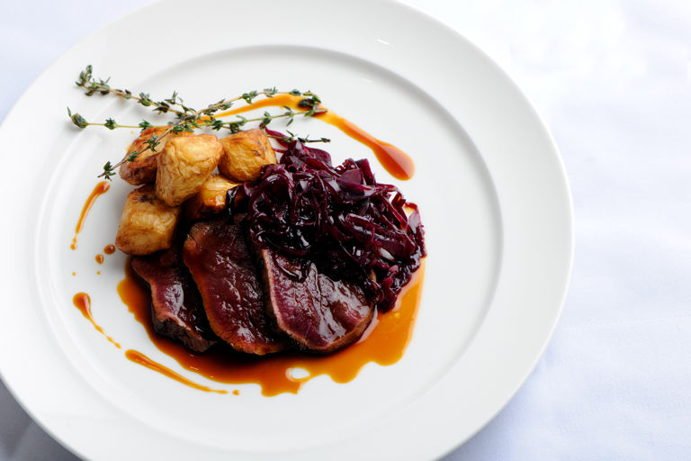Venison leg cooked in hay with roast celeriac and braised red cabbage