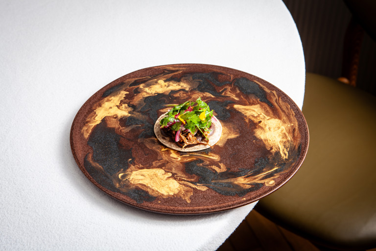 Churrasco (barbecued) lamb breast, black bean feijoada and cassava tacos